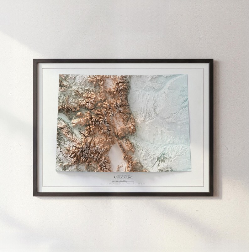 K&ouml;nnte beinhalten: Eine gerahmte topografische Karte von Colorado mit kontrastreichem Reliefdesign. Der westliche Teil zeigt detaillierte braune Gebirgsz&uuml;ge, w&auml;hrend der &ouml;stliche Bereich flache, helle Ebenen darstellt. Der Text lautet Topographic Map of Colorado.