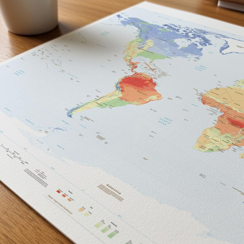 May include: A world map print on textured paper featuring a K&ouml;ppen-Geiger climate classification color scheme. The map displays continents in shades of blue, green, yellow, orange, and red, with a legend at the bottom and Antarctica labeled.