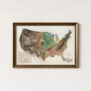 May include: Framed 3D relief map of the United States, showcasing topographical features in shades of green, brown, and blue. The map is encased in a gold-toned wooden frame, suitable for home decor.