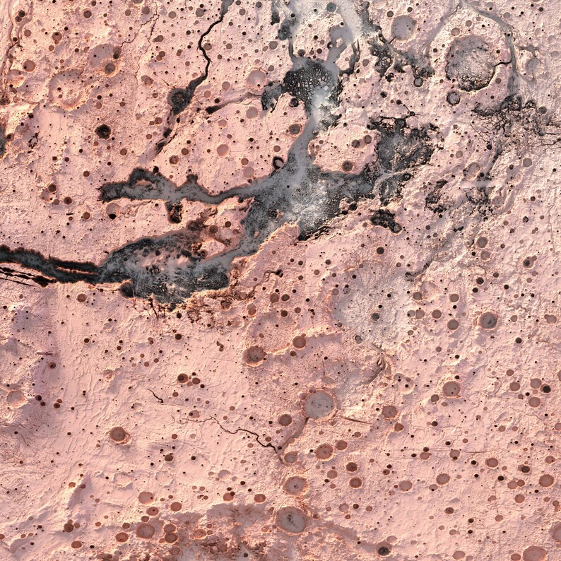 May include: An aerial view of a pink and grey landscape with a network of cracks and craters. The surface is textured and uneven, with a variety of sizes and shapes of craters.