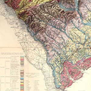 Pode incluir: Um mapa vintage do sudeste dos Estados Unidos, mostrando as forma&ccedil;&otilde;es geol&oacute;gicas e os sistemas fluviais. O mapa &eacute; codificado por cores para indicar os diferentes tipos de rocha e solo. O mapa &eacute; intitulado "Mapa geol&oacute;gico dos estados do sul".
