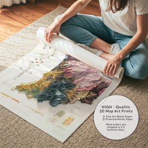 May include: A detailed 2D map art print, with a rolled section and a visible topographical map in shades of green, yellow, blue, and purple. The print is on matte paper. The text on the print reads "HIGH - Quality 2D Map Art Prints".