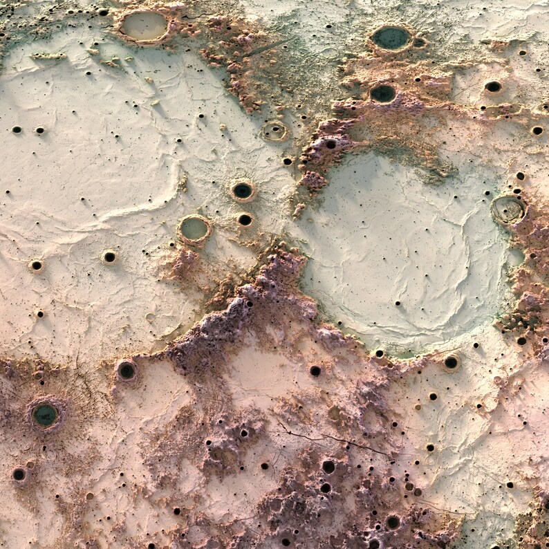 May include: A close-up of a cratered surface with a variety of colors, including beige, brown, and green. The surface is covered in small craters and has a rough texture.