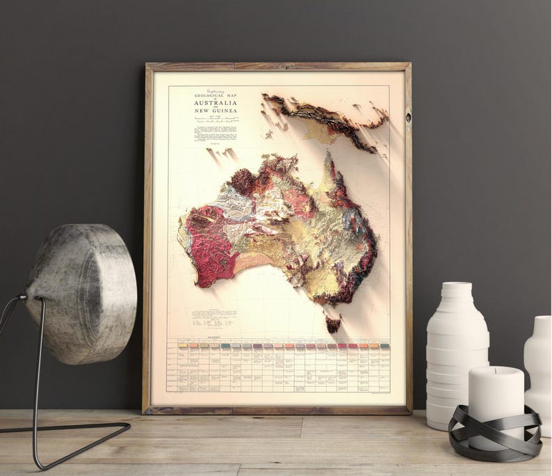 May include: A framed vintage map of Australia and New Guinea with a detailed geological map of the continent. The map is printed in shades of brown, red, and yellow, with a key at the bottom showing the different geological formations.