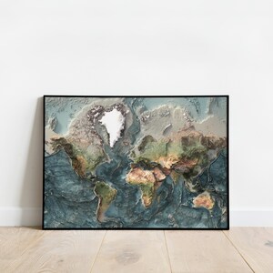 May include: A framed world map with a 3D effect, showing the continents in shades of green, brown, and blue. The map is framed in black and has a white background.