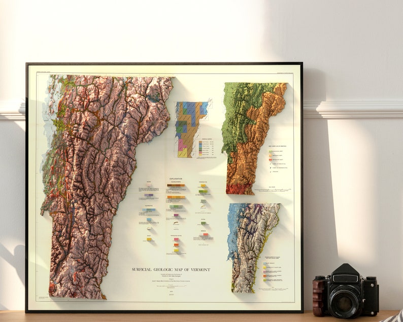 K&ouml;nnte beinhalten: Eine Vintage-geologische Karte von Vermont mit einem 3D-Relief-Effekt. Die Karte ist in Abschnitte unterteilt, die jeweils eine andere geologische Formation darstellen. Die Karte ist in einem schwarzen Rahmen gerahmt und auf einer Holzoberfl&auml;che ausgestellt.
