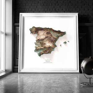 Pode incluir: Uma impress&atilde;o emoldurada branca de um mapa topogr&aacute;fico da Espanha. O mapa est&aacute; em tons de verde, marrom e bege, mostrando o terreno do pa&iacute;s. O t&iacute;tulo "Mapa topogr&aacute;fico da Espanha" est&aacute; impresso abaixo do mapa.