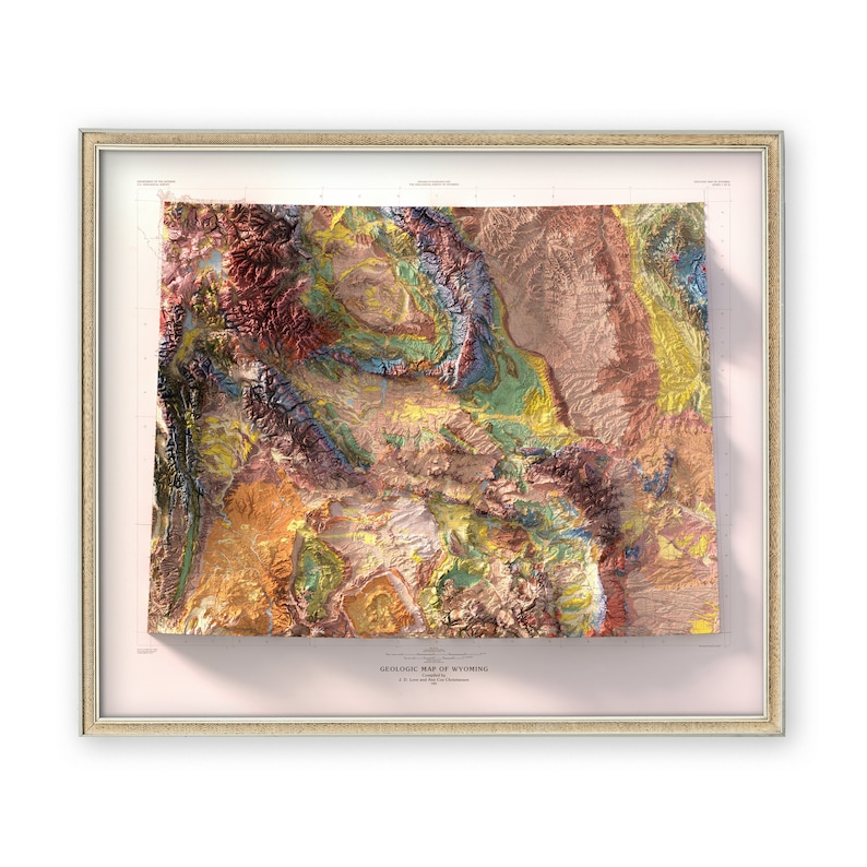 Puede incluir: Un mapa geol&oacute;gico vintage enmarcado de Wyoming, que muestra las diversas formaciones rocosas del estado en un estilo de relieve 3D colorido. El mapa est&aacute; titulado "GEOLOGIC MAP OF WYOMING" e incluye un cr&eacute;dito para el U.S. Geological Survey.