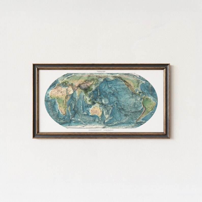 May include: A framed oval world map print featuring detailed topographical relief of continents and ocean floors in shades of blue, green, and tan. The map is enclosed in a dark, textured wooden frame with a thin gold inner border.