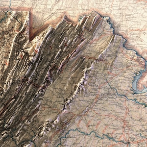 May include: A detailed, vintage map of a mountainous region, likely a state or area in the United States. The map features shaded relief, highlighting the topography with brown and beige tones. Red lines indicate roads, and text labels identify cities and geographical features.