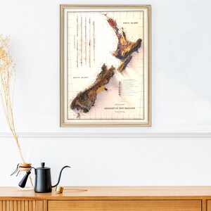 May include: A vintage map of the geology of New Zealand, printed in shades of brown, yellow, red, and blue. The map shows the North Island and South Island, with the text "Geology of New Zealand" printed at the bottom.