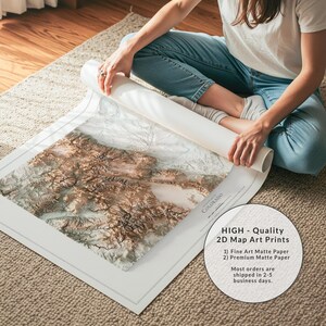 K&ouml;nnte beinhalten: Ein gro&szlig;er, aufgerollter Kunstdruck mit einer detaillierten topografischen Karte von Colorado, die braune Gebirgsz&uuml;ge und wei&szlig;es, verschneites Gel&auml;nde zeigt. Der Druck enth&auml;lt den Text COLORADO und einen wei&szlig;en Rand auf mattem Papier.