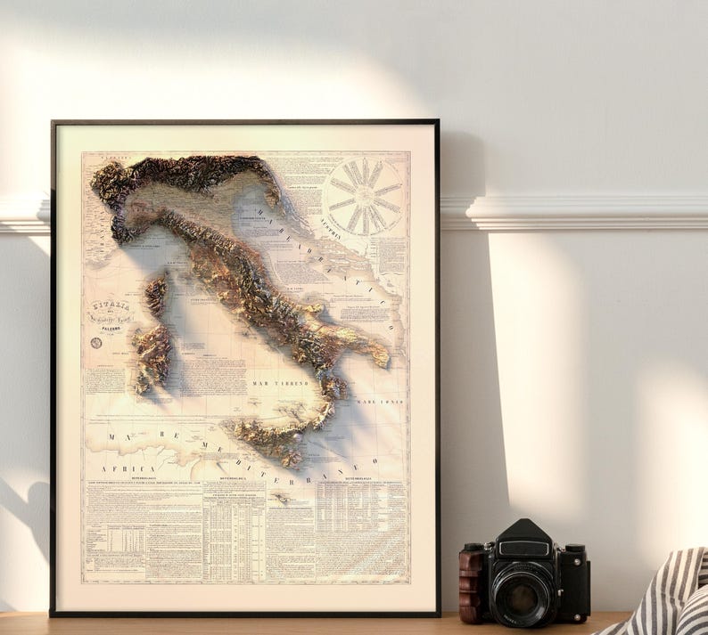 May include: A vintage-style map of Italy with a 3D embossed effect, showing the country's topography. The map is printed on a cream-colored paper with brown text and details. The map is framed in a black frame.