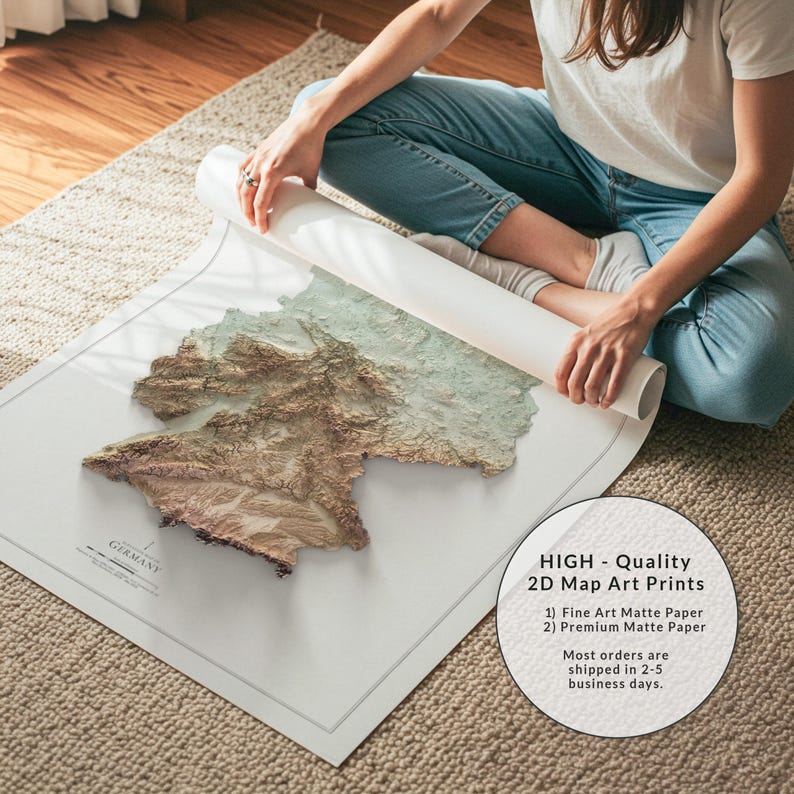 May include: A detailed 2D map art print of Germany, featuring a relief-style design with brown and green tones. The map is on a white matte paper, with the word "GERMANY" printed at the bottom. The image also includes text that says "HIGH - Quality 2D Map Art Prints".