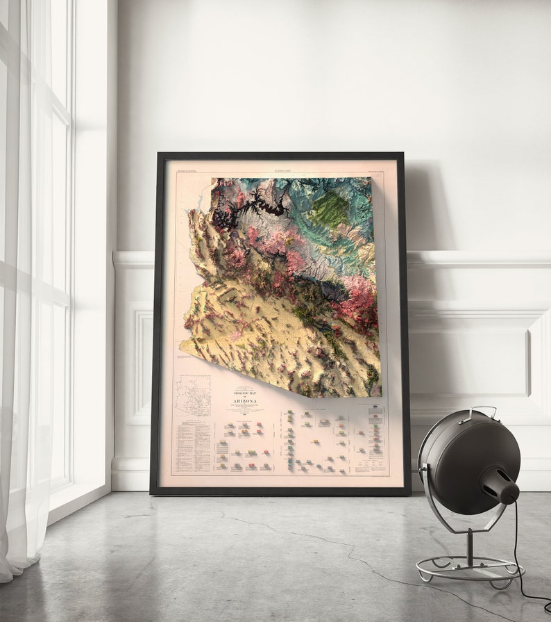 May include: A vintage-style relief map of Arizona, framed in black, with a detailed key of geological formations and elevations. The map is printed on a cream-colored paper with a light pink background.