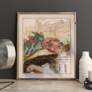 K&ouml;nnte beinhalten: Eine Karte von Deutschland im Vintage-Stil, die die Topographie des Landes mit verschiedenen Farben und Texturen zeigt. Die Karte ist in einem Holzrahmen gerahmt und tr&auml;gt den Titel "Deutschland in seinen Grenzen".