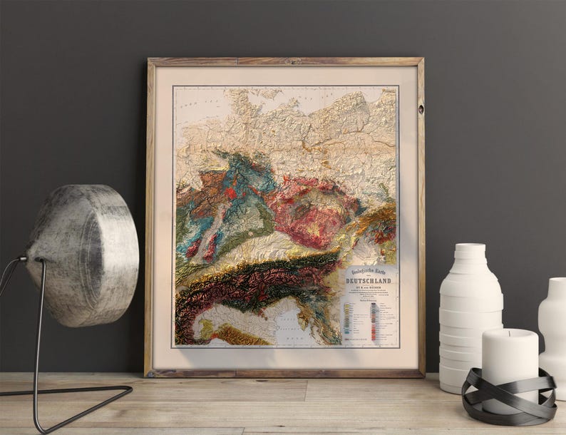 K&ouml;nnte beinhalten: Eine Karte von Deutschland im Vintage-Stil, die die Topographie des Landes mit verschiedenen Farben und Texturen zeigt. Die Karte ist in einem Holzrahmen gerahmt und tr&auml;gt den Titel "Deutschland in seinen Grenzen".