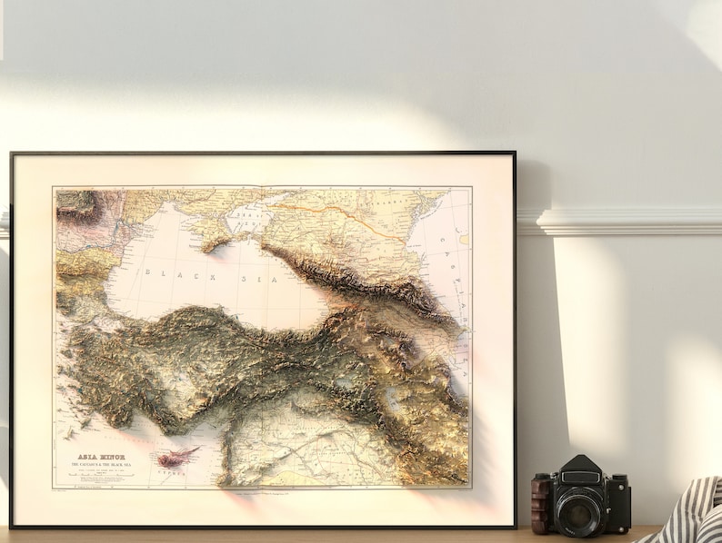 May include: A vintage map of Asia Minor, also known as Anatolia, with the text "ASIA MINOR THE EASTERN SHORE OF THE BLACK SEA" printed at the bottom. The map is framed in black and features a detailed topographic relief of the region.