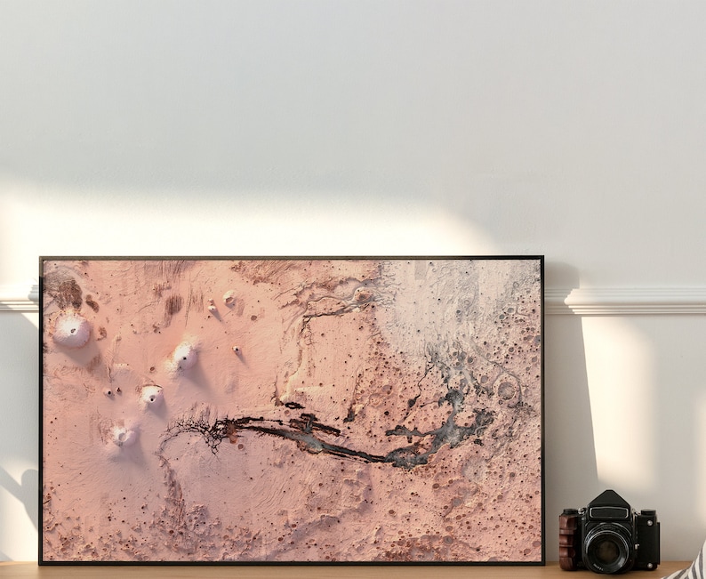 May include: A framed abstract art print with a pink and black colour scheme. The print features a textured, abstract design with a black river-like shape running through the centre.