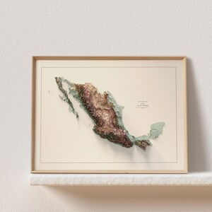 May include: A framed 3D relief map of Mexico, showcasing the country's topography in shades of brown and green. The map is set against a cream-colored background and enclosed in a light wooden frame. The text "Elevation Map Mexico" is visible.