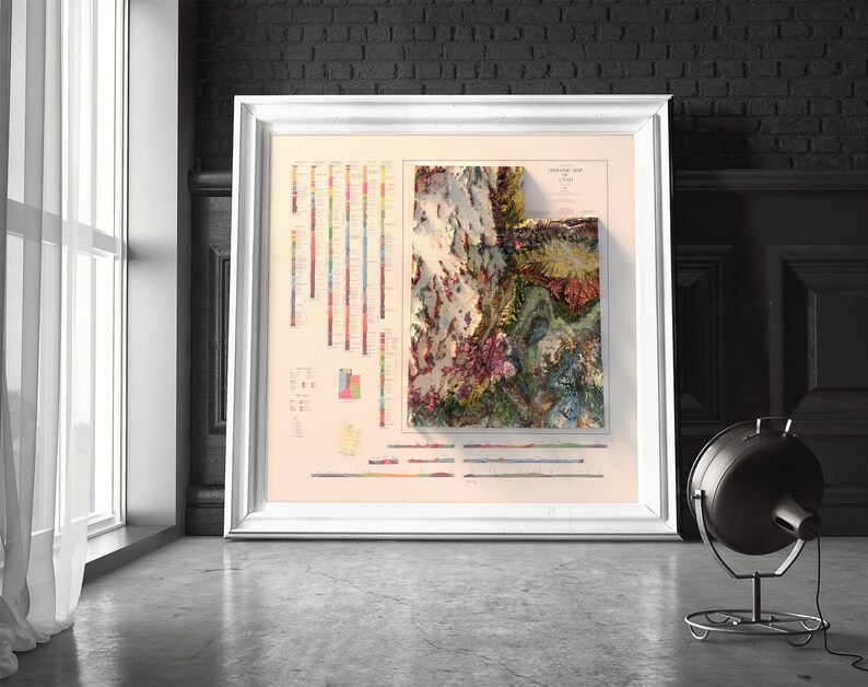May include: A framed map of Utah with a 3D relief design. The map is printed in shades of green, brown, and blue, with a key showing the different elevations. The map is surrounded by a white frame.