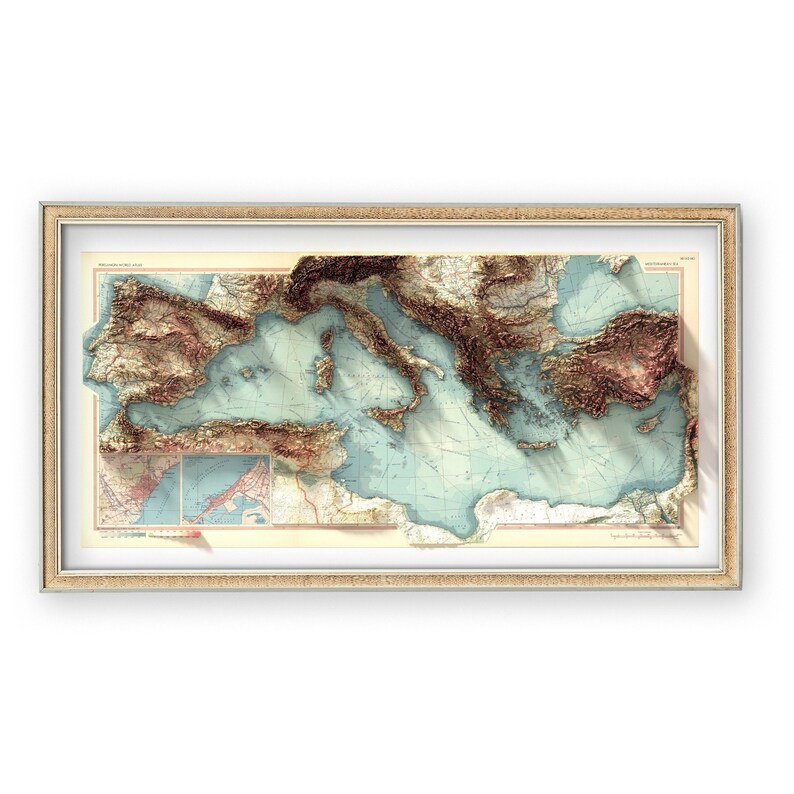 May include: A vintage-style, framed map of the Mediterranean Sea with a 3D embossed effect. The map features detailed topography with brown and green hues for land and blue for water. The frame is a light brown wood.