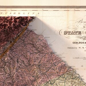 May include: A vintage map of North Carolina with a detailed geological survey. The map is printed in brown, black, and white ink on a cream-colored paper. The map shows the state's rivers, mountains, and other geographical features.