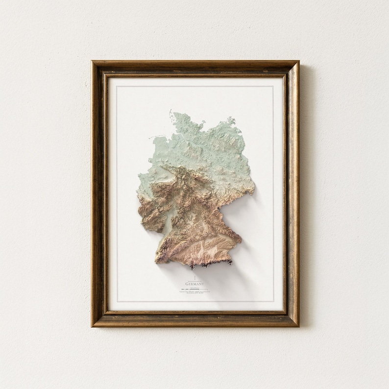 May include: A framed 3D map of Germany, depicting the country's terrain in brown, green, and white hues. The map is set against a white backdrop, enclosed within a gold-coloured frame, suitable for wall decor.