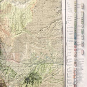 May include: A detailed topographic map with a vintage aesthetic. The map features shaded relief, contour lines, and place names. The color palette includes shades of green, brown, and beige, with a key and legend along the right side.