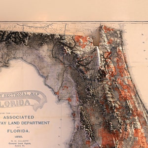 May include: A vintage map of Florida, showing the state's geography and land divisions. The map is printed on a cream-colored paper with brown and black lines and text. The map is titled "Sectional Map of Florida" and is dated 1890.