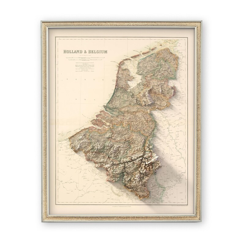Pode incluir: Um mapa vintage da Holanda e da B&eacute;lgica com um efeito de relevo 3D. O mapa &eacute; impresso em papel cor de creme e emoldurado em uma moldura de madeira clara.