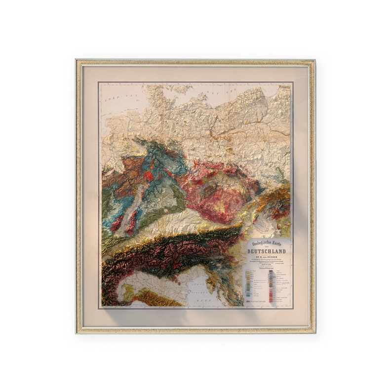 K&ouml;nnte beinhalten: Eine gerahmte Vintage-Karte von Deutschland, die die geologischen Formationen des Landes zeigt. Die Karte ist in einem hellbraunen Rahmen mit einem wei&szlig;en Passepartout. Die Karte ist mit "Geologische Karte Deutschlands" betitelt und zeigt die verschiedenen Arten von Gesteinsformationen im Land.