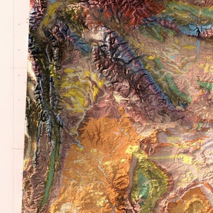 Puede incluir: Un mapa geol&oacute;gico detallado de una regi&oacute;n monta&ntilde;osa, que muestra diversas formaciones rocosas y caracter&iacute;sticas geol&oacute;gicas en tonos marrones, verdes, amarillos y morados.