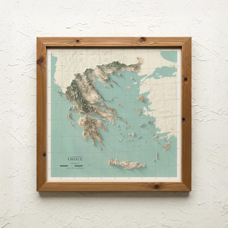 May include: A framed topographic map of Greece featuring a three-dimensional relief effect. The map displays landmasses in cream and water in a muted teal, set within a natural wood frame. Text on the map reads Topographic Map of Greece.