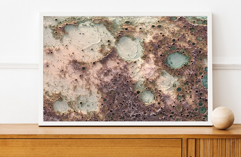 May include: Abstract art print featuring a textured, cratered surface in shades of brown, pink, and green. The print has a distressed, vintage look.