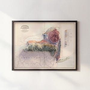 May include: Framed vintage map of New York State, featuring a 3D topographic relief. The map displays a detailed view of the state's terrain, with colors indicating elevation changes. The frame is black, and the map includes text at the top.