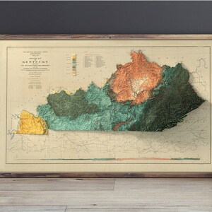 May include: A vintage map of Kentucky with a 3D relief effect, showing the state's topography with different colors representing elevation. The map is framed and hanging on a wall.