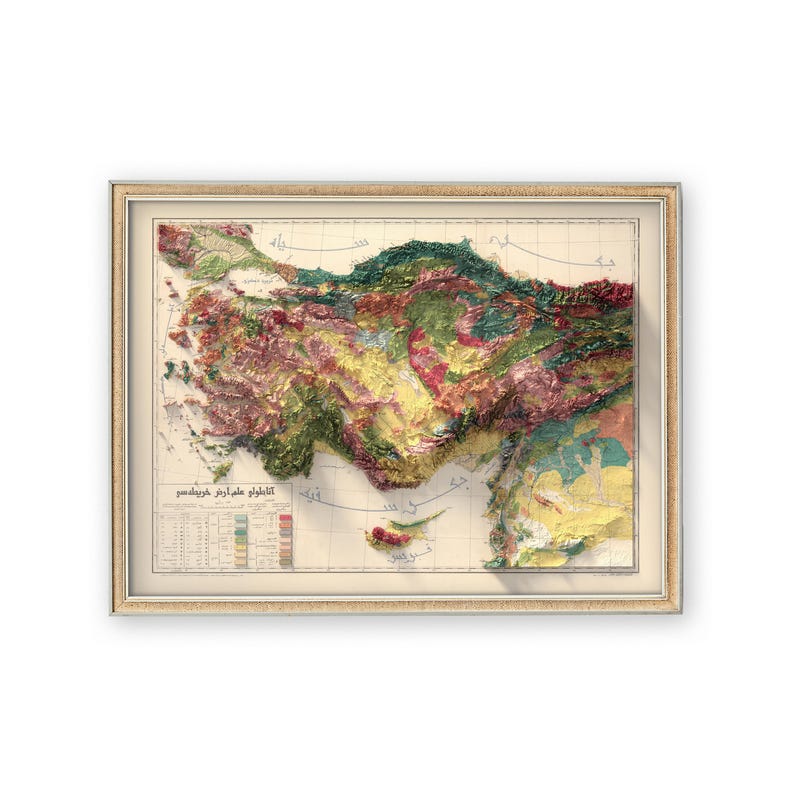 May include: A vintage, framed map of Turkey with a 3D relief effect. The map is printed in shades of green, brown, and yellow, with a grid pattern and text in Turkish. The map is framed in a light wood frame.