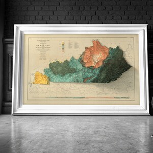 May include: A vintage map of Kentucky in a white frame. The map is a relief map showing the different elevations of the state. The map is in shades of green, yellow, and orange.