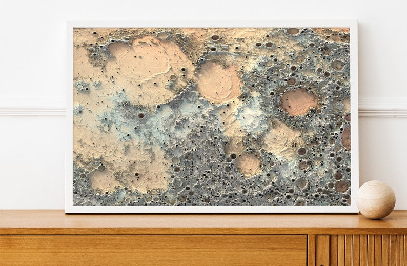 May include: A digital art print featuring a close-up of a textured surface with craters and holes in shades of gray, beige, and light blue.