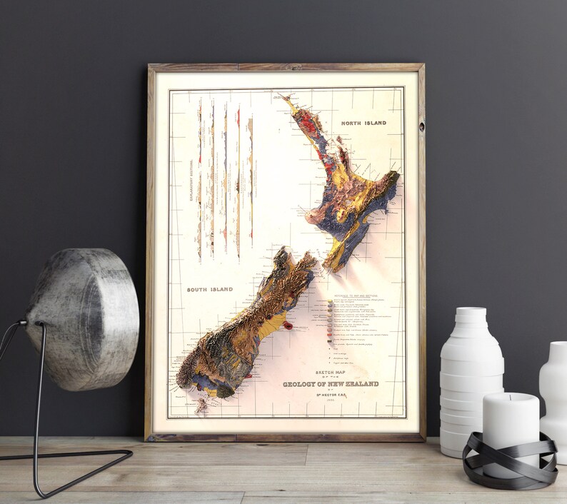 May include: A vintage geological map of New Zealand, framed in a brown wood frame. The map shows the different geological formations of the North and South Islands, with a key to the different rock types. The map is titled "Sketch Map Geology of New Zealand by Arthur S. Eakins."
