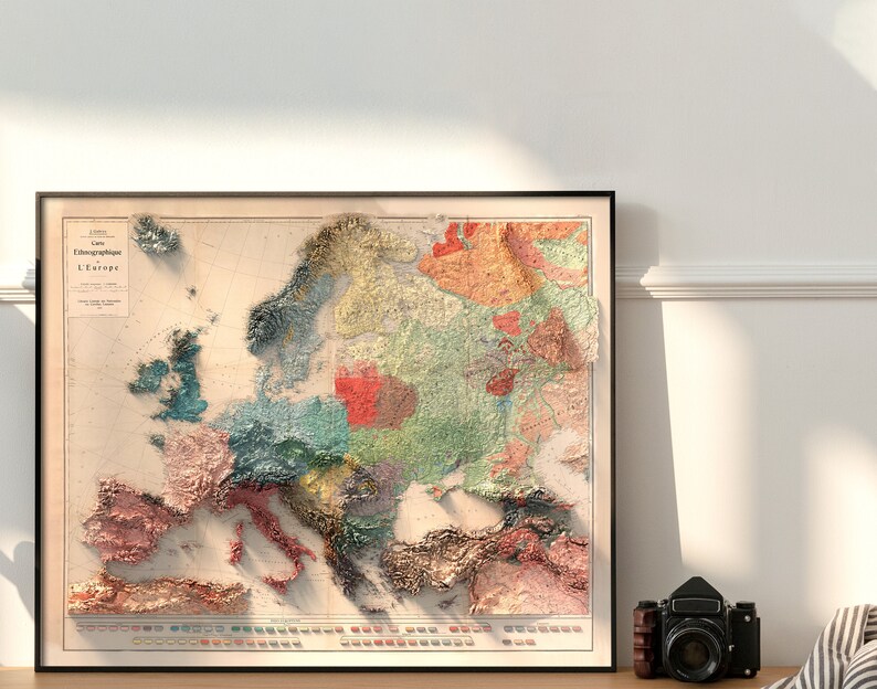 Op de afbeelding: Een vintage kaart van Europa met een 3D-effect, die de verschillende regio's in verschillende kleuren laat zien. De kaart heeft de titel "Carte Ethnographique de L'Europe".