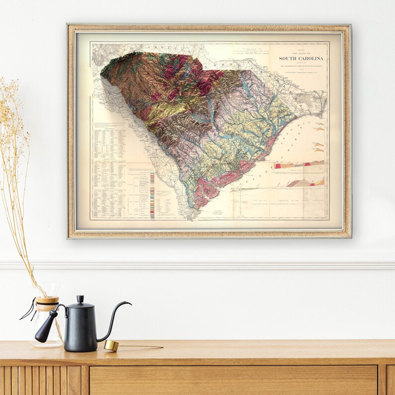 Pode incluir: Mapa vintage da Carolina do Sul com topografia e caracter&iacute;sticas geol&oacute;gicas detalhadas. O mapa &eacute; impresso em marrom, verde, vermelho e azul sobre um fundo branco. O t&iacute;tulo "The State of South Carolina" &eacute; impresso no topo do mapa.