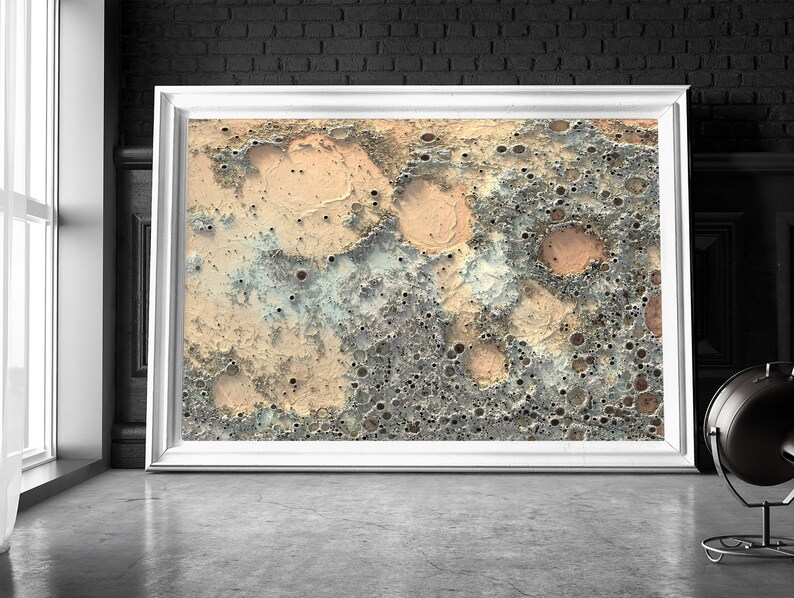 May include: Abstract art print featuring a textured, cratered surface in shades of beige, brown, and blue. The print has a distressed, vintage look.