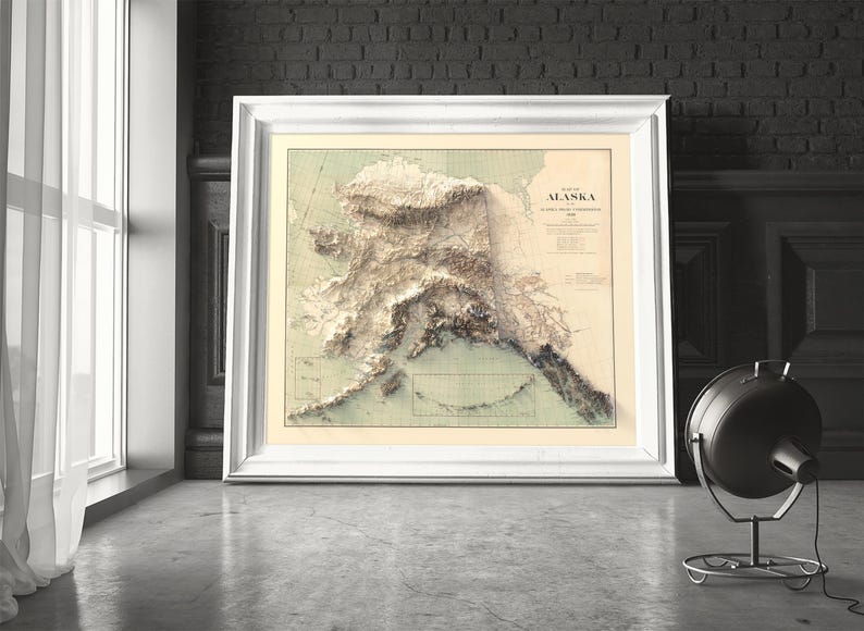 White wooden framed Alaska map art as a romantic gift. The print features the Arctic National Wildlife Refuge and Northern Lights hues, symbolizing enduring adventure—perfect for anniversaries, elopement mementos, or celebrating a life-changing Alaskan journey together.
