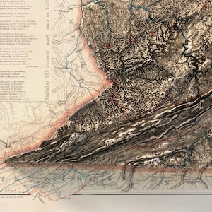 May include: Antique map with detailed topographical features, including mountains, rivers, and roads. The map uses a sepia-toned color palette with red and blue accents. Text labels indicate locations and distances. The map is a historical document.
