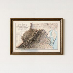 May include: Framed vintage map of Virginia, featuring detailed topography and state boundaries. The map is in a gold-toned wooden frame. The title "Map of the State of Virginia" is visible at the top. The map shows the state's rivers, mountains, and cities.