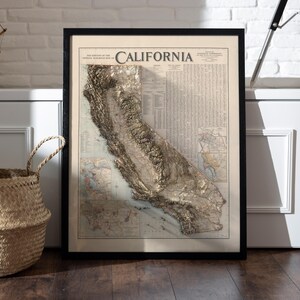 K&ouml;nnte beinhalten: Eine gerahmte Vintage-Karte von Kalifornien mit einem 3D-Reliefdesign. Die Karte ist in Schwarzwei&szlig; mit beigefarbenem Hintergrund und zeigt die Topographie des Bundesstaates.