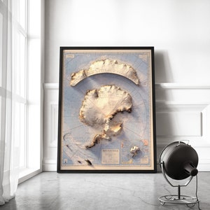 May include: A vintage-style map of Antarctica in a black frame. The map is printed on a light blue background with brown and white details. The map shows the continent's coastline, major features, and surrounding islands. The word "ANTARCTICA" is printed in the lower right corner of the map.