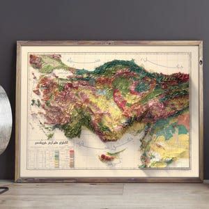 May include: A vintage, framed map of Turkey with a 3D relief effect. The map is printed in various shades of green, brown, yellow, and red, depicting the country's topography. The map includes a legend and a title in Turkish.